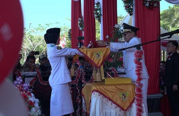 Ketgam Inspektur Upacara Surunuddin Dangga saat menyerahkan bendera merah putih kepada pasukan Paskibraka untuk dikibarkan.