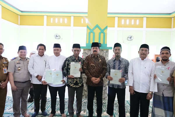 Ketgam Foto bersama Menteri ATRBPN bersama pengurus rumah ibadah usai penerimaan sertifikat wakaf tanah.